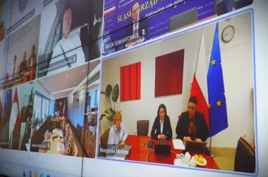 Wielkoformatowy ekran wyświetla wideokonferencję z udziałem przedstawicieli instytucji publicznych, w tym województwa lubuskiego i śląskiego urzędu wojewódzkieg